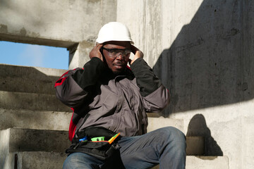 African american worker at project site has headache, he touches his head