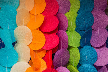 Decoration in the form of many multi-colored circles hanging on threads close-up	
