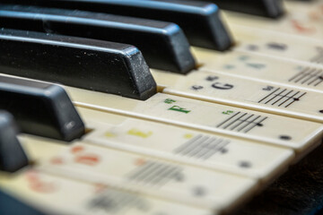 Black and white keys of synthesizers with stickers of notes close-up 
