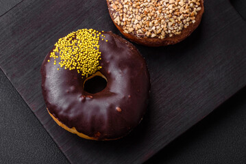 Delicious donut with cream filling and nuts on a dark concrete background