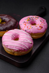 Delicious donut with cream filling and nuts on a dark concrete background