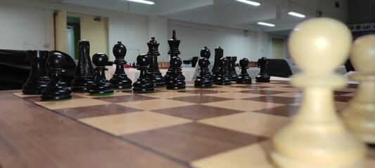 Wooden chessboard with chess pieces on it. Wooden chess board with chess pieces. - obrazy, fototapety, plakaty