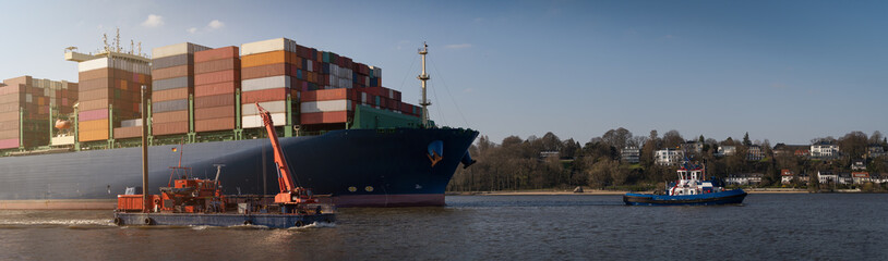 Large container ship arrives in the port of Hamburg in sunny weather 