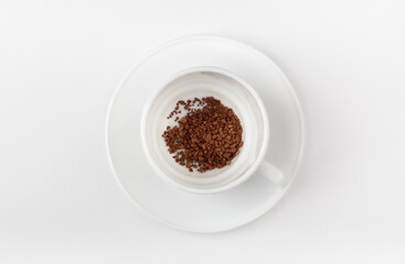 A white cup with instant coffee on a white background. Blank cup. Top view.