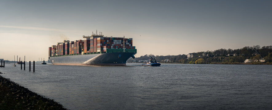 Large container ship arrives in the port of Hamburg in sunny weather