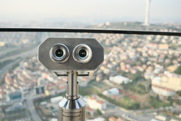 Coin-operated binoculars looking out over city ,