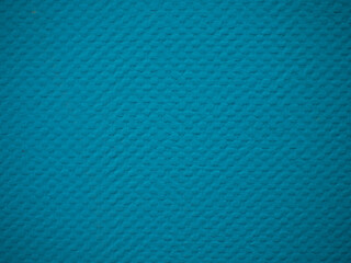 Textured background of a plasterboard wall that has been wallpapered for painting and painted blue. Wallpaper for painting with a beautiful blue texture. Background, close-up.