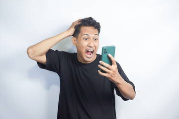 Smart Young Asian man is confused, angry and stresses when look smartphone in studio background.