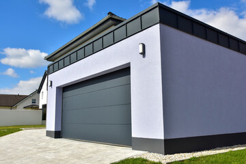 Moderne Beton-Garage mit Automatik-Tor in der Hauszufahrt