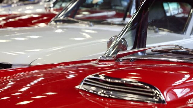 Dolly shot of details on vintage retro cars painted in red and white.