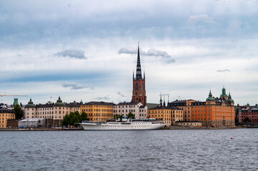 Fototapeta na wymiar Stockholm, Sweden - Panorama of old town Gamla Stan with church and tower. Waterfront with old houses and boats.