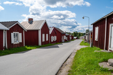Fototapeta na wymiar Gammelstad, Lulea, Sweden - street with small red historic wooden houses. A protected heritage village in the north of Europe.