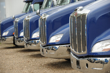 Obraz na płótnie Canvas row of blue semi trucks at dealership