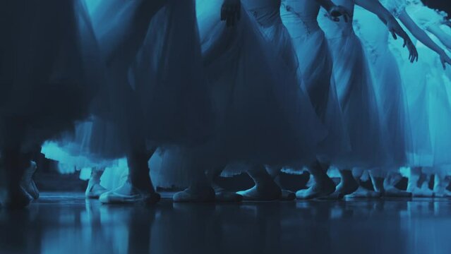 The ballerina stand in a row and change the position of her legs. then they run out of the frame. dance of ballerinas on stage. The position of the legs in ballet