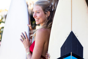Fototapeta na wymiar Happy caucasian woman holding surfboard at beach