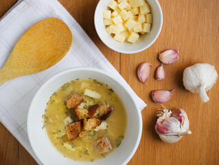 Bowl of a traditional Czech and Slovak garlic soup (called cesnecka or oukrop) cooked from broth, garlic, potatoes, cumin and egg and served with cheese and croutons. Traditional Czech, Slovak dish.