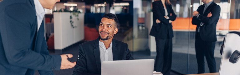 Busy multiethnic coworkers cooperating and working together at office meeting, teamwork concept