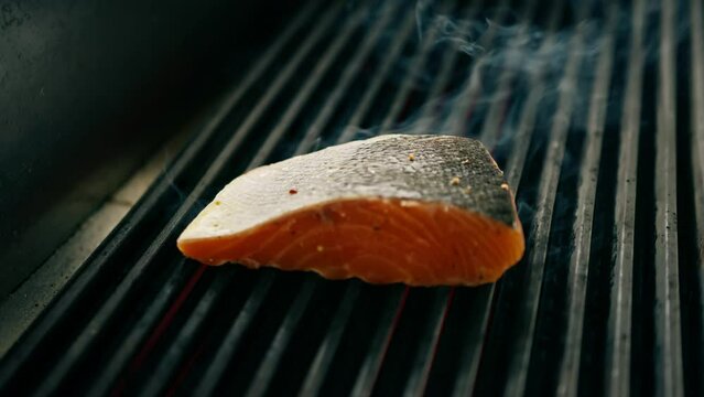 A professional kitchen in a hotel restaurant close-up of a juicy piece of fresh salmon on the grill
