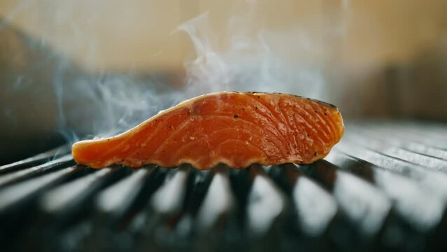 A professional kitchen in a hotel restaurant close-up of a juicy piece of fresh salmon on the grill