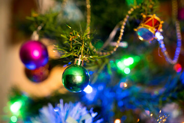 Christmas decorations, balls, and garlands in an artificial tree with lights. Background for an invitation card or greetings