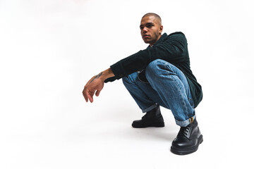 attractive young man with stylish clothes squatting, full shot isolated on white background. High quality photo