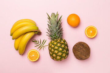 Fresh tropical fruits on color background, top view