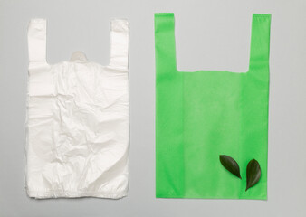 Plastic and biodegradable bag on color background, top view