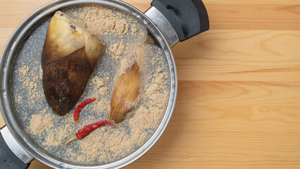 鍋にタケノコと米糠(こめぬか)と唐辛子を入れてアク抜きする　イメージ