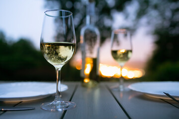 Romantic dinner and sunset view. Wine glasses on table in a beautiful nature setting 