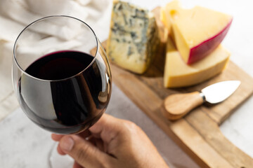 Cheese board with a glass of red wine.