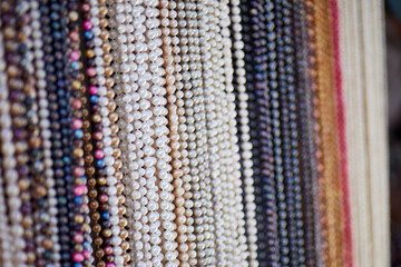 Handmade Strands of Assorted Pearl Necklaces hanging on a Rack