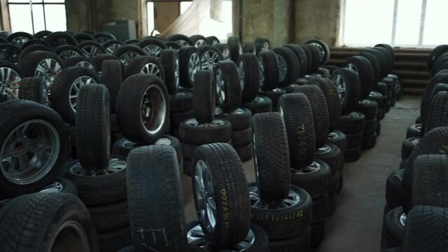 modern warehouse with stack of car tires with metal disk, auto repair service
