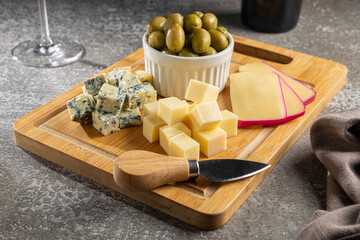 Plate of different cheeses with a glass of wine. Cheese board.