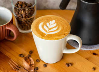 Hot Latte Mocha art with coffee beans, fork, spoon served in dish isolated on wooden table top view of taiwan food