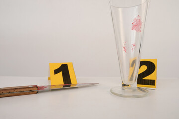 crime scene with evidence markers, idfresh splatter of red blood on glass goblet, bloody knife,...