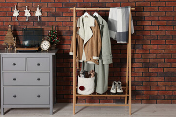 Modern hallway interior with Christmas decor and stylish furniture near red brick wall