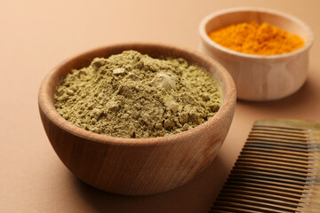 Comb, henna and turmeric powder on beige background, closeup. Natural hair coloring