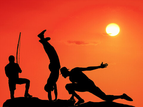Capoeira fight at sunset. It is a Brazilian martial art, developed by Angolans slaves, in the 16th century. The capoeira was granted a status as intangible cultural heritage by UNESCO. Salvador, 2020.