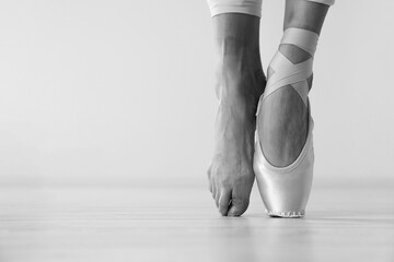 Ballerina in pointe shoe dancing, closeup with space for text. Black and white effect