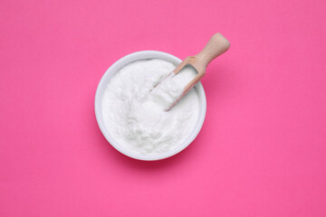 Bowl of sweet powdered fructose on pink background, top view