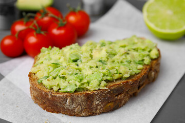Delicious sandwich with guacamole on parchment paper, closeup