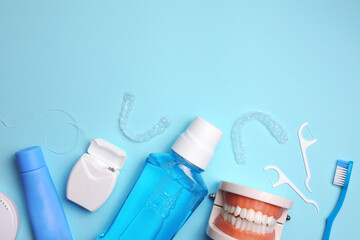 Transparent plastic dental aligners and care products on a colored background
