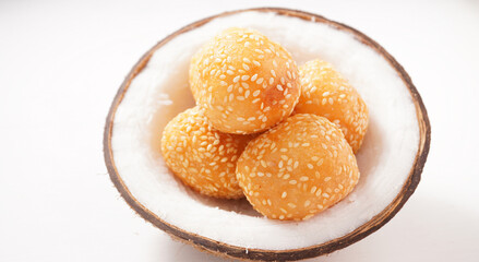 Thai dessert sesame balls stuffed with fried mung beans in a coconut shell