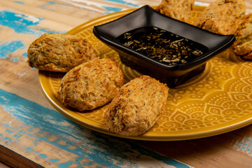 Fried cod fritters in portions, with a bowl of olive oil