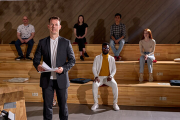 Portrait of handsome caucasian professor lecturer with interracial group of university students in...