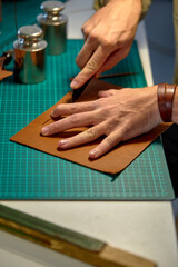 craftsman hands master cut with a knife to skin products. Small business, close up cropped shot, process of working with leather