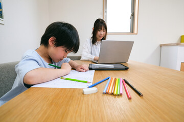 テレワークする母親と宿題をする子供