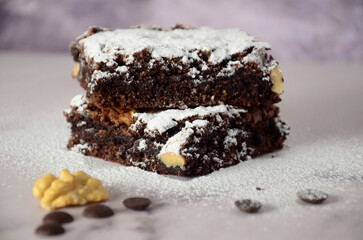 Chocolate brownie with icing sugar and nuts