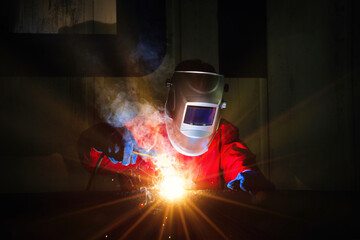 Industrial worker at the factory welding closeup. Workers wearing industrial uniforms and welded...