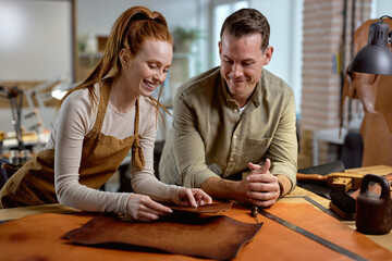 happy craftmen learning to work with leather in the workshop, close up photo. happiness, positive emotions